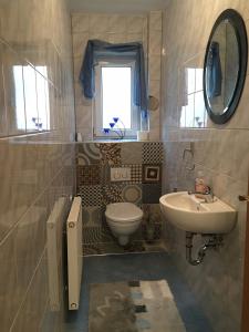 Un baño con lavabo, inodoro y ventana. en Apartment Gosberg - 90qm, en Pinzberg