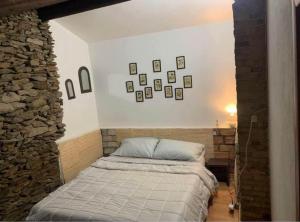 une chambre avec un lit et un mur en pierre dans l'établissement Villa Lidia, à Quartu SantʼElena