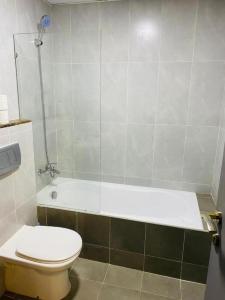 a bathroom with a toilet and a bath tub at Royal Manor- Marina Diamond 2 in Dubai