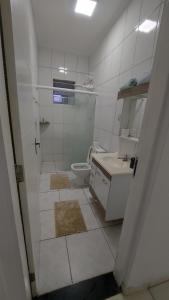 a white bathroom with a toilet and a sink at Casa térrea no centro ideal para famílias e trabalho in Mogi das Cruzes