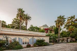 an exterior view of a house with palm trees at Villa Irlanda Grand Hotel in Gaeta