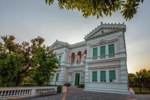 a large white building with green windows at Villa Irlanda Grand Hotel in Gaeta