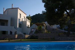 a house and a swimming pool in front of a house at Xenon Estate in Spetses