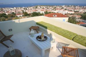 a balcony with a bench and a table at Xenon Estate in Spetses