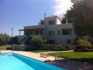 a house with a swimming pool in front of it at Xenon Estate in Spetses