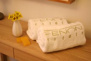 two towels sitting on a counter with a vase of flowers at Xenon Estate in Spetses