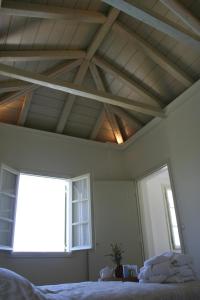 a bedroom with a ceiling with a window and a bed at Xenon Estate in Spetses