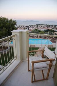 a balcony with a chair and a view of the water at Xenon Estate in Spetses