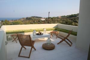 a patio with a table and chairs on a balcony at Xenon Estate in Spetses