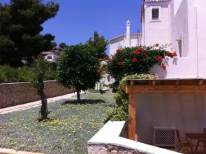 a garden in front of a white building with flowers at Xenon Estate in Spetses