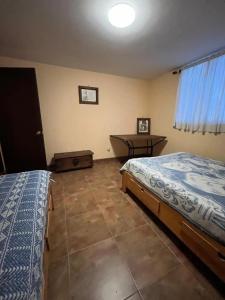 a bedroom with two beds and a desk in it at Cabaña El Tigrito in Quiroga
