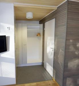 um quarto com um corredor com uma porta e uma televisão em Camping Merihelmi em Myllykangas