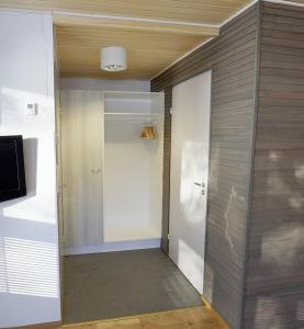a room with a hallway with a door and a television at Camping Merihelmi in Myllykangas