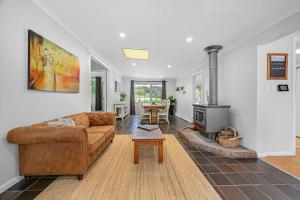 奥兰治Meadowbrook MTB Lodge Orange - Rip on the trails, sip on the wine!的带沙发和壁炉的客厅