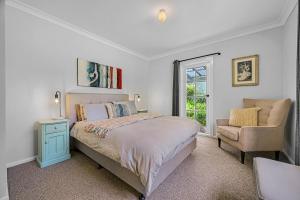 奥兰治Meadowbrook MTB Lodge Orange - Rip on the trails, sip on the wine!的一间卧室，里面有一张床、一把椅子和一扇窗户