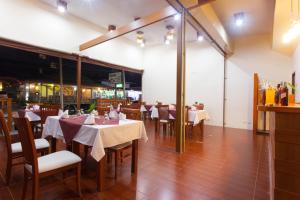 uma sala de jantar com mesas e cadeiras brancas em Chalong Princess Pool Villa Resort SHA EXTRA PLUS em Chalong