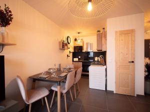 ein Esszimmer mit Tisch und Stühlen und eine Küche in der Unterkunft Charmant T2 à Valmorel avec parking et casier à ski - FR-1-291-1016 in Valmorel + 7 Fotos