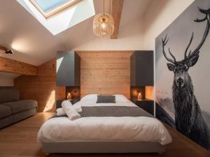 ein Schlafzimmer mit einem großen Bett mit einem Hirschgemälde an der Wand in der Unterkunft Bel appartement 5 pièces à Valmorel avec parking, 8 pers. - FR-1-291-1018 in Valmorel