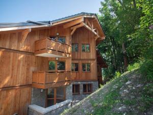 ein Holzhaus mit Balkon auf einem Hügel in der Unterkunft Bel appartement 5 pièces à Valmorel avec parking, 8 pers. - FR-1-291-1018 in Valmorel