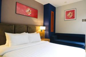 a bedroom with a large bed and a blue chair at Nicecy NganHa Hotel in Ho Chi Minh City
