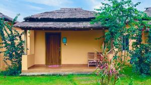 a small yellow house with a wooden porch at Angel Eco Resort, Cox Bazar in Dhoāpālong