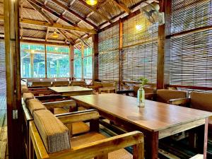 an empty restaurant with wooden tables and chairs at Angel Eco Resort, Cox Bazar in Dhoāpālong +20 photos