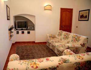 a living room with a couch and a tv at Maragani Beach in Maragani