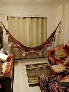 a room with a hammock in front of a curtain at Quarto Simples em Apto Charmoso in Maceió