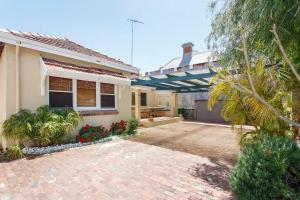 ein Haus mit einer gepflasterten Auffahrt davor in der Unterkunft Directors Cottage Fabulous Local & Peaceful in Fremantle