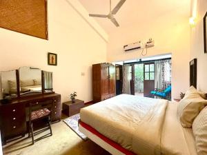 a bedroom with a bed and a dresser and a mirror at Casa Maya - 2 Bedroom Portuguese Villa with Private Pool in Candolim