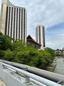a bridge over a river with two tall buildings at Mizie Hotel Kuala Lumpur in Kuala Lumpur