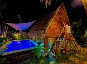 a small house with a swimming pool next to a building at GAïA Cabinhouse in Cebu City