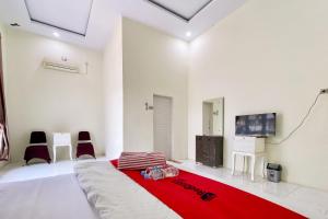 sala de estar con cama grande con manta roja en RedDoorz Syariah at RPCC Rantauprapat, en Rantauprapat