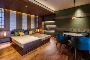a bedroom with a bed and a table and chairs at Oyado The Earth in Toba