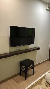 a flat screen tv on a wall with a table at Mizie Hotel Kuala Lumpur in Kuala Lumpur