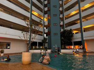 a group of people sitting in a pool in a building at Mutiara Melaka Beach Resort in Kampong Pantai Dusun +30 photos