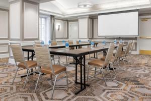 a conference room with a table and chairs and a white screen at Courtyard St. Louis Downtown/Convention Center in Saint Louis