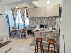 a kitchen with a counter and stools in a room at Ela Home Concept Residence in Iaşi