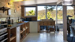 cocina con encimera y ventana grande en Artists Garden Cottage, en Hepburn Springs