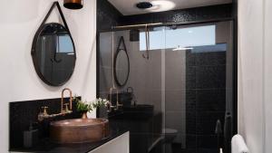 un baño con lavabo y espejo en Artists Garden Cottage, en Hepburn Springs 13 fotos más