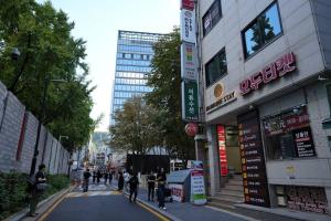 a group of people walking down a street in a city at Mumune Stay in Seoul