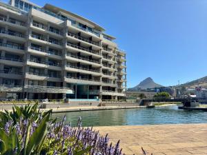 a large apartment building next to a body of water at Waterfront Canal Luxury Apartment in Cape Town