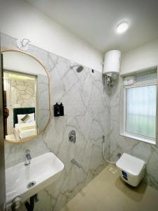 a bathroom with a sink and a mirror and a toilet at The Orion Premium Suites in Mumbai +57 photos