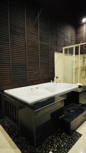 a large bathroom with a large tub and a sink at Vela House Phuket in Changwat Phuket