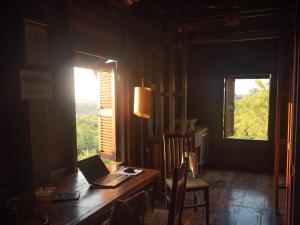 a room with a table with a laptop on it at Garden View Lodge & Trekking Tours in Banlung
