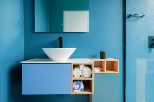 a bathroom with a sink and a blue wall at EQ SURF RETREAT in Muli +56 photos