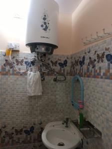 a bathroom with a toilet and a light on the wall at RaghuvarDham Delux AC 1 Double Bed, 1 Single Bed Room in Ayodhya