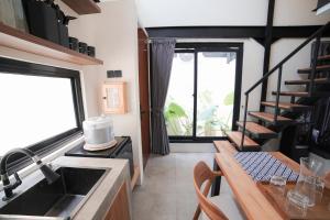 a kitchen with a sink and a counter with a table at Ubu Villa Alston in Yogyakarta in Yogyakarta