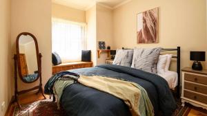 a bedroom with a bed with a mirror and a dresser at Honeycomb Lodge in Daylesford