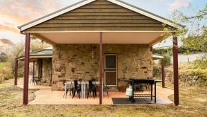 a pavilion with a table and chairs and a grill at Honeycomb Lodge in Daylesford